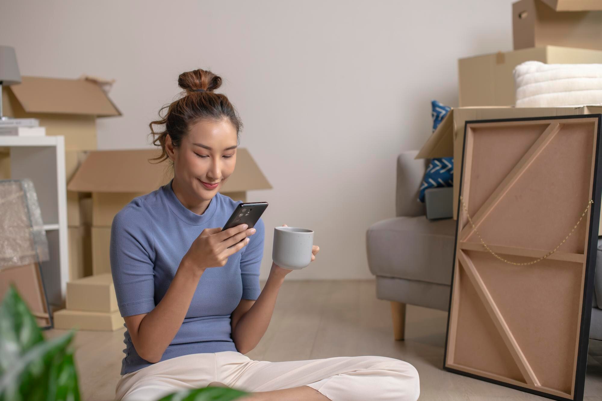 Person i nytt hem med smartphone, som illustration till adressverifiering som misslyckas efter flytt