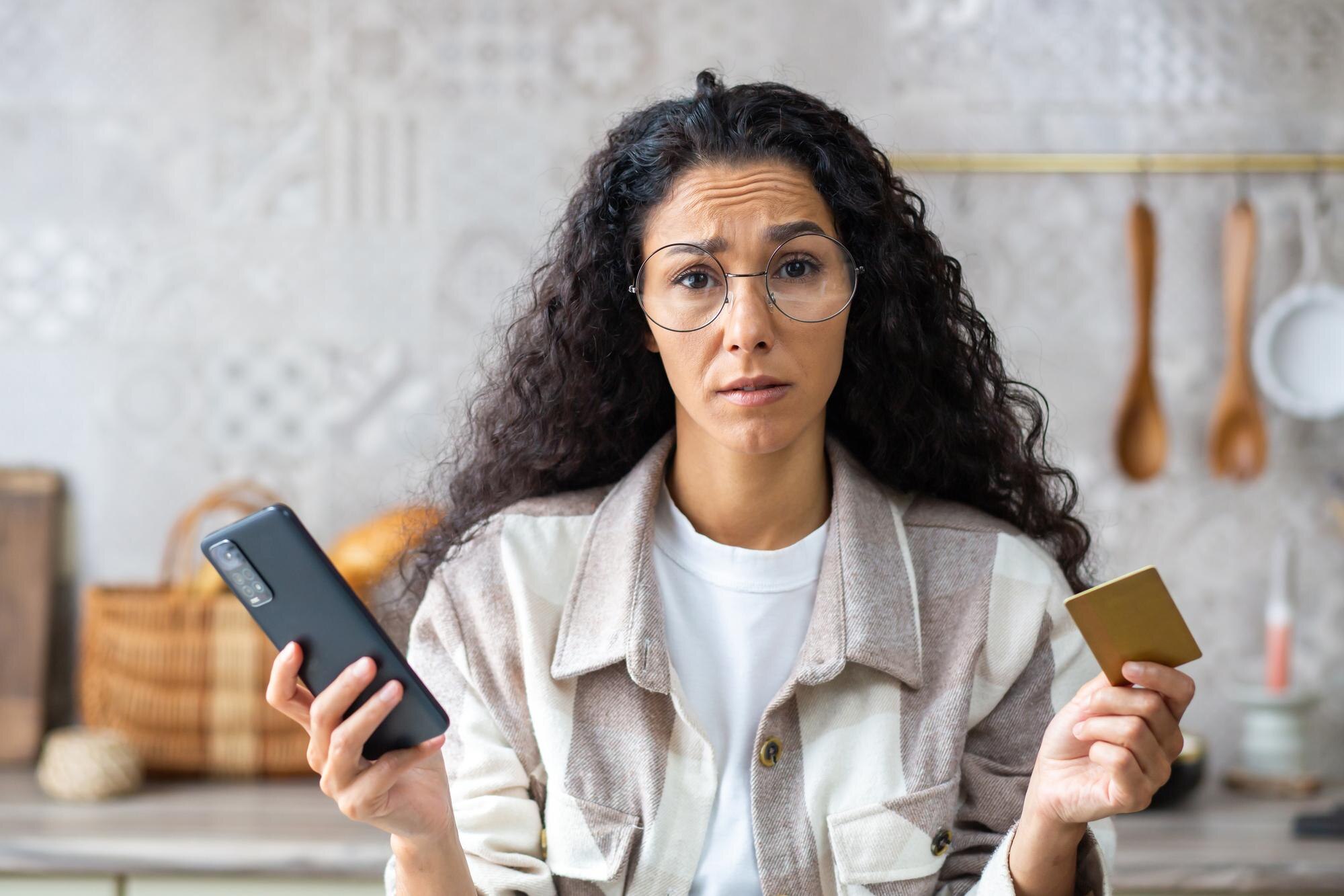 Person med smartphone och bankkort efter misslyckad onlinebetalning, som illustration till nekad kortbetalning på casino