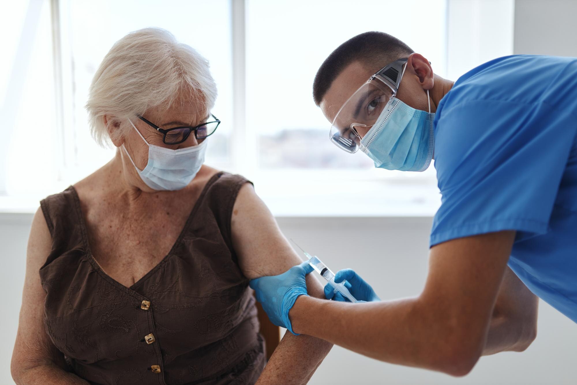 Äldre kvinna får vaccin av läkare inför höstens covid-19-vaccination 2026