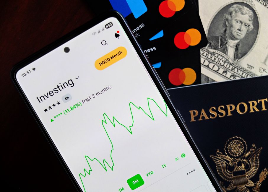 Smartphone med finansapp, kort och kontanter som illustrerar digitalisering och fintech i banksektorn