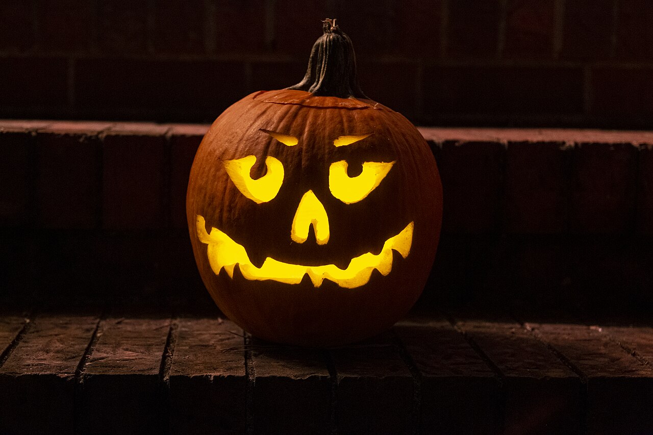 Glödande utskuren Halloweenpumpa fotograferad i mörker