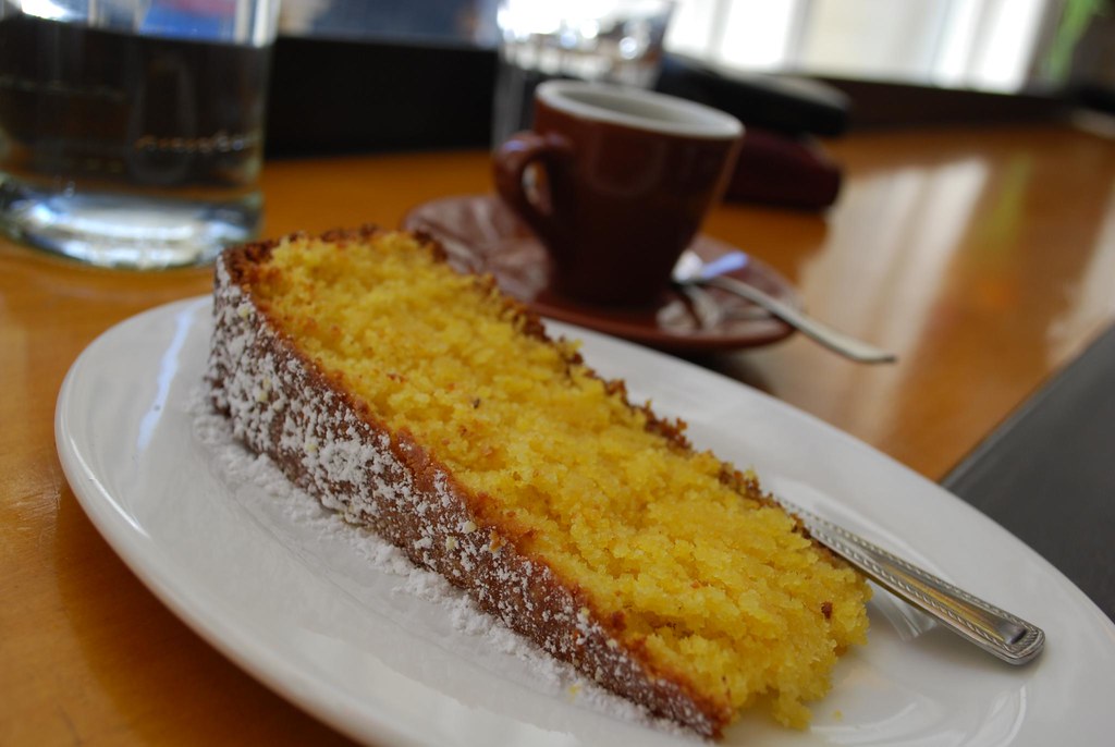 Kaffe och en bit citronkaka serverade på ett cafébord