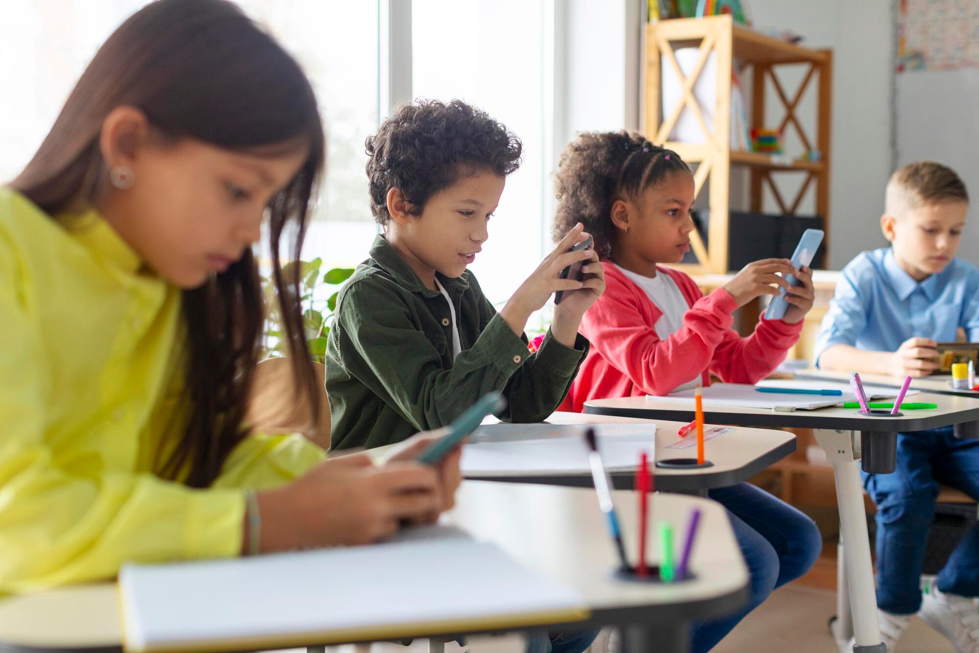 Illustrationsbild av skolelever med mobiltelefoner i klassrum inför reglerna om mobilfri skola 2026