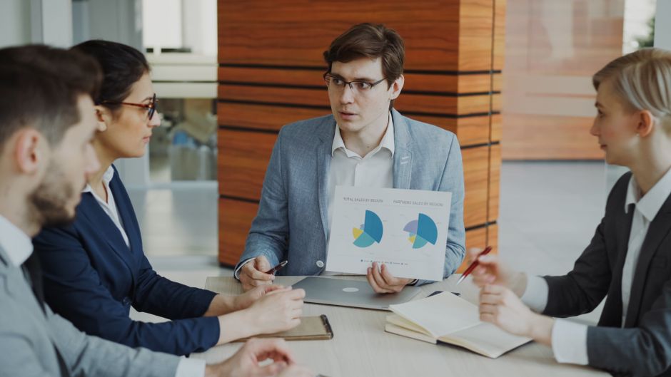 Illustrationsbild: ett team diskuterar diagram och strategi på ett kontor. Bilden är inte från Riksbankens företagsundersökning och föreställer inte de intervjuade företagen.